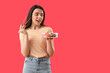 © Pixel-Shot - Young woman with sushi rolls and chopsticks on red background