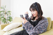 © maroke - 家でスマートフォンを使う若い女性