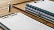 © Kittiya - Blank checklist on a clipboard next to a pen and a stack of clipboards on a wooden desk.