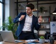 © Denis Chubchenko - Happy businessman in a suit dancing at his office desk with a laptop and wireless earbuds, celebrating corporate success or profit.