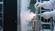 © Rachakrit - Gloved technician adjusting cryogenic vaporizer in laboratory emitting mist, clinical environment, precision work