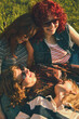 © master1305 - Close up of young women resting together on grass with retro effect. Concept of intimate friendship, warm emotions, nostalgic summer portrait, and relaxed outdoor lifestyle.