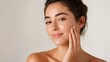 © Premium Foods - Beautiful young woman with glowing skin touching her face, looking at camera, studio portrait
