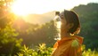 © Karma - Woman balancing clear water bottle on her forehead in a sunny, green, nature setting with golden light