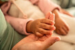 © ADDICTIVE STOCK - Latin mother holding baby daughter hand in warm closeup