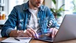 © Busness studio - Professional reviews payroll documents and financial analytics on laptop with futuristic digital interface overlay