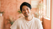 © Shousei - 30代日本人男性の落ち着いた表情を自然光で表現。マットなコーラル背景が柔らかな印象を演出。