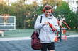 © New Africa - Young man with sports bag, headphones and bottle of water at outdoor gym