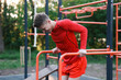 © New Africa - Athletic young man exercising on parallel bars at outdoor gym