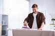 © New Africa - Man ironing curtain on board at home