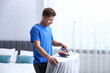 © New Africa - Man ironing curtain on board at home