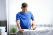 © New Africa - Man ironing curtain on board at home