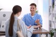 © New Africa - Medical assistant helping patient at desk in clinic