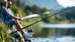 © Nataliya - Anonymous male friends or brothers fishing at a lake, outdoor hobby and active lifestyle concept, faceless, defocused nature background, with copy space