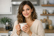 © vefimov - Smiling woman enjoying a cup of coffee in the kitchen