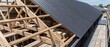 © Febcherl Studio - Construction Site Progress Featuring Wooden Roof Trusses And Dark Corrugated Metal Roofing Panels For A Modern Residential Home