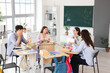 © Pixel-Shot - Group of teenage students studying at desks in classroom