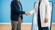 © Oleg - Older white man shaking hands with a doctor beside a giant smartphone in a modern clinic. Telehealth consultation and digital healthcare support for remote patient care and medical communication.