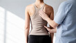 © Victoria - physiotherapist examining back of woman in clinic. Manual therapist checking spine and muscle alignment. Healthcare professional providing rehabilitation, posture assessment and pain treatment