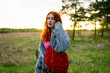 © TrueShot | Westend61 - Red-haired model in denim jacket listening to music outdoors
