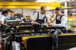 © BusinessClass by W61 - Mechanics inspecting an engine indoors at a manufacturing plant