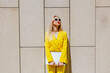© VISTA by Westend61 - Happy freelancer wearing yellow suit holding laptop outside