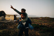© Julia - Friends share a playful piggyback moment during a sunset roadside adventure