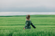 © VISTA by Westend61 - Female manager in green suit listening to music in wheat field