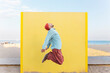 © VISTA by Westend61 - Energetic tourist jumping in superhero pose on a sunny beach
