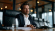 © Maksym - Male entrepreneur sitting alone at a pitch table in an empty boardroom presentation clicker in hand chair opposite him vacant funding rejection fear of failure moment startup anxiety business risk p