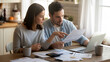 © Infinity in the lens - Couple reviewing household bills and financial documents at home. Budget planning, personal finance, money management, financial stress and family budgeting concept.