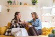 © Westend61 - Mother and daughter talking and drinking coffee at home