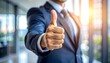 © EPDICAY - Businessman gives thumbs-up gesture in bright office setting