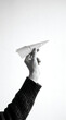 © amirfaoezan - Hand Holding Paper Airplane Against White Background