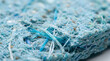 © Kaniz Fatema - Recycled Material Texture: A close-up macro shot reveals the intricate texture of a recycled composite material, showcasing mixed fibers and fragments in shades of blue and earth tones.