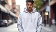 © menn - Young man wearing a white hoodie, standing on a city street, looking at the camera, urban fashion, casual style