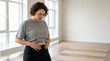 © Xenia - Woman checking her waistline in a fitness studio. Concept of body awareness and weight loss journey