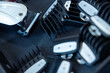 © Suntaraporn - Set of black plastic hair clipper guards in an organizer tray on a barber workstation.