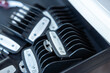 © Suntaraporn - Set of black plastic hair clipper guards in an organizer tray on a barber workstation.
