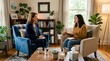 © MDASHIR - Smiling female therapist engaging in positive conversation with young woman in bright sunny office with many plants.