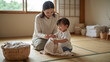 © bephoto - 休日の和室で日本人の母親が子供に洗濯物の畳み方を教えている