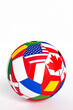 © theshooter - Balón de fútbol con banderas de distintos países sobre fondo negro, concepto de deporte internacional, competición mundial de futbol, diversidad cultural y la unión mundial