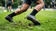 © spyrakot - Football boots kicking up turf during sprint on grass field