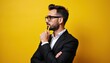© Pete - Man in suit thinks with pencil. Businessman considers ideas with serious face. Person ponders deep thoughts, contemplates future, makes decision. Young professional on yellow background.