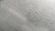 © Fauzi - close-up of a scratched metal surface, possibly stainless steel or aluminum. The texture is rough, with numerous fine and deep scratches crisscrossing in various directions, creating a worn and aged