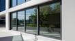 © Oleksandr - Modern grey frame sliding glass doors on white building exterior. Seamless transition from interior to exterior space with green plants. Contemporary architecture for home or office.