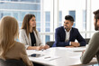 © fizkes - Four successful professional business team members engaged in discussing in meeting room, listening Spaniard woman colleague, express opinion, provide information and thoughts during briefing event
