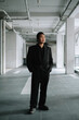 © David - Serious Indonesian man in black suit standing in industrial walkway