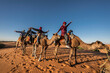 © Cavan Images - group of friends enjoying a camel ride in the Sahara