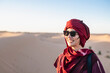 © Cavan Images - portrait of woman wearing a turban in the Sahara desert
